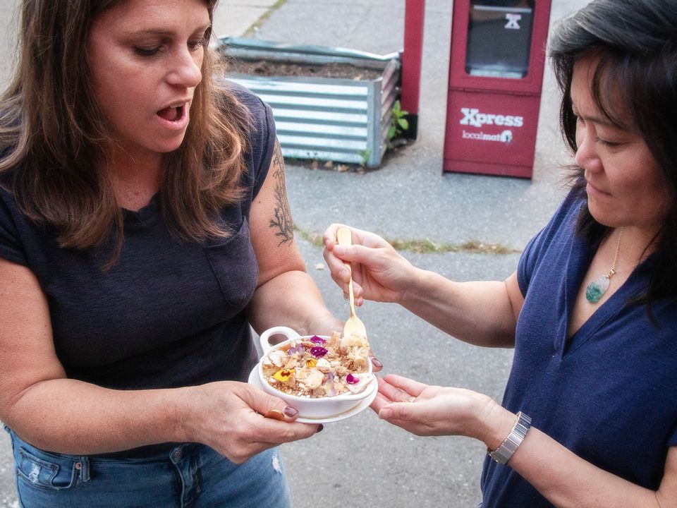 Two members of the Marketing Outpost team tasting a dish outside a local restaurant